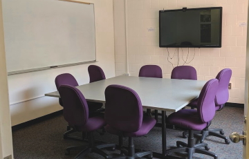 Room 309 with table, chairs, display screen, and whiteboard